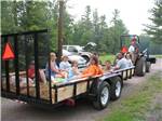 People riding on the back of a trailer at WHISPERING PINES CAMPING ESTATES - thumbnail