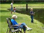 A couple of kids fishing in the pond at WHISPERING PINES CAMPING ESTATES - thumbnail