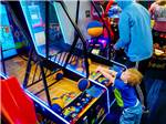A little boy playing one of the arcade games at THE HILL CAMPGROUND - thumbnail