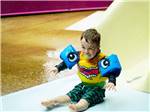 A baby boy sliding down a water slide at THE HILL CAMPGROUND - thumbnail