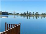 View larger image of Wood railing in foreground of large lake at WAKESIDE LAKE RV PARK image #8