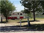View larger image of Red and white retro trailer on grassy campsite at WAKESIDE LAKE RV PARK image #9