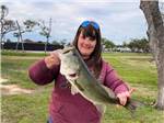 View larger image of Woman holding up hefty fish recently caught at SOUTHERN OAKS RV RESORT image #10