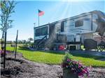 View larger image of Fifth-wheel parked with patio and American flag at SOUTHERN OAKS RV RESORT image #12