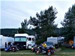 RVs in campsites with campers and their motorcycles at NO NAME CITY LUXURY CABINS & RV PARK - thumbnail