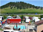 Campground with pool and scenic hill in background at NO NAME CITY LUXURY CABINS & RV PARK - thumbnail