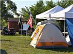 Campground tent area with flags, motorcycles at NO NAME CITY LUXURY CABINS & RV PARK - thumbnail