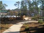 View larger image of Concrete path to the pool area at WHISPERING PINES RV PARK image #5