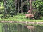A park bench along the water at WOODLAND PARK - thumbnail