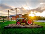 View larger image of Antique tractor and barn at park entrance at RUSTIC MEADOWS RV PARK image #1