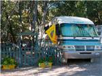 RV parked next to blue picket fence - thumbnail