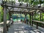 Pergola with people overlooking the water at HIDDEN PARADISE CAMPGROUND - thumbnail