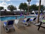 Lounge chairs around the swimming pool at PALMDALE RV RESORT - thumbnail