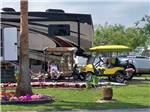 A man and golf cart by a motorhome at PALMDALE RV RESORT - thumbnail