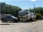 A black pickup near a fifth wheel trailer - thumbnail