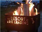 View larger image of A lit fire pit with the resort logo at THE RESORT AT ERIE LANDING image #1