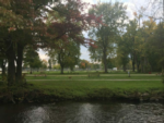 View of park with tables and creek at Veterans Memorial Park (Village Park) - thumbnail