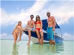 Two couples standing next to a boat in the water nearby at BIG PINE KEY & FLORIDA LOWER KEYS - thumbnail