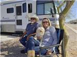 View larger image of A couple sitting with a dog at COPPER MOUNTAIN RV PARK image #8