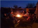 View larger image of A group of people sitting around a fire pit at COPPER MOUNTAIN RV PARK image #12