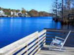 An adirondack chair on a deck overlooking water - thumbnail
