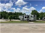 Fifth wheel parked at a gravel site at Camping World-Campground of Oxford - thumbnail