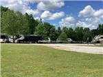 Grassy area next to a gravel RV site at Camping World-Campground of Oxford - thumbnail