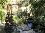 Small pond with wooden path and wind chimes  at WHISPERING PINES - thumbnail