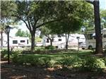 Motorhome and trailers parked by a shady area at WHISPERING PINES - thumbnail