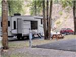 A fifth wheel parked next to a picnic bench at CRYSTAL GOLD MINE & RV PARK - thumbnail