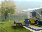 View larger image of A picnic table by a trailer at FARM COUNTRY CAMPGROUND image #11