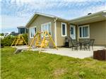 Rental cabin with swing and outdoor seating at Bas-St-Laurent Campground - thumbnail