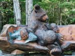 A bear holding a fish wood carving - thumbnail
