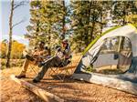 A couple sitting outside of their tent - thumbnail