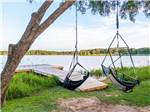 View larger image of A dock and swinging chairs by the water at TWIN LAKES CAMP RESORT image #12