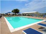 View larger image of Large swimming pool with blue lounge chairs at SHADY CREEK RV PARK AND STORAGE image #1