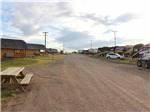 The gravel road with cabins on one side and sites on the other side at SHELBY RV PARK AND RESORT - thumbnail