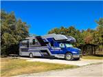 A blue and silver big rig RV parked in a paved site at Hidden Cove Park - thumbnail