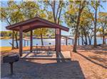 Covered picnic tables by the lake at Hidden Cove Park - thumbnail