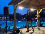 View larger image of A couple singing on the stage by the pool at MOOSE HILLOCK CAMPING RESORT NY image #5