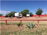 Wooden fence with RVs parked onsite at WILD WEST RV PARK - thumbnail