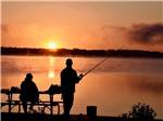 People fishing at the lake at sunset - thumbnail