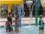Kids standing under the waterfalls in the splash zone at PALMETTO SHORES RV RESORT - thumbnail