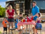 Family at picnic bench with RV in background LAKE COMPOUNCE CAMPGROUND - thumbnail