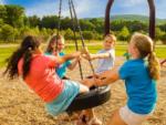 Children on a tire swing in the playground at LAKE COMPOUNCE CAMPGROUND - thumbnail