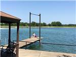 View larger image of A lady fishing on the dock at FLAT CREEK FARMS RV RESORT image #11