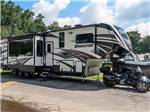 Fifth-wheel parked near motorcycle at SWEETWATER CREEK RV RESERVE - thumbnail