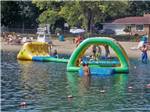 View larger image of People playing on the inflatable water toys at CRYSTAL LAKE RV PARK image #5