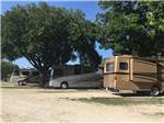 Class A motorhomes parked in gravel sites at TREE CABINS RV RESORT - thumbnail