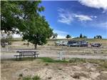 A row of gravel RV sites with picnic tables at CHOTEAU MOUNTAIN VIEW RV CAMPGROUND - thumbnail